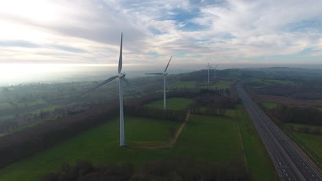 Renewable-green-energy-wind-turbines-along-highway-in-Normandy.-Aerial-drone